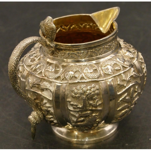 241 - An Eastern silver coloured metal round bulbous shaped milk jug with serpent shaped handle and allove... 