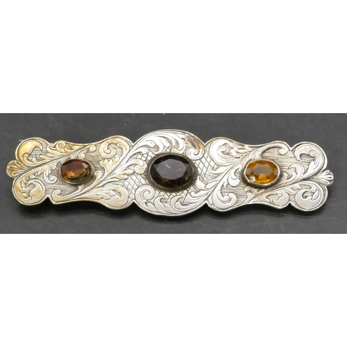 405 - A Scottish style silver rectangular brooch set with 3 coloured stones with engraved decoration, 7.6c... 