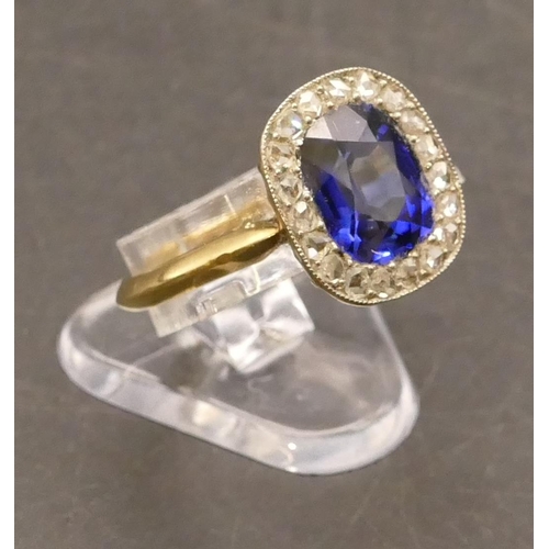 697 - An 18ct gold cluster ring set with centre blue stone surrounded by small diamonds, Size P/Q