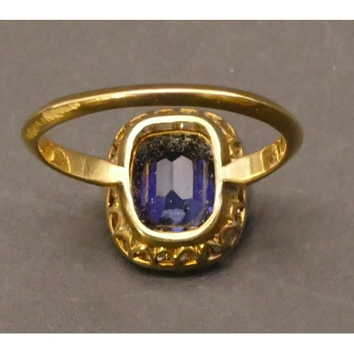 697 - An 18ct gold cluster ring set with centre blue stone surrounded by small diamonds, Size P/Q