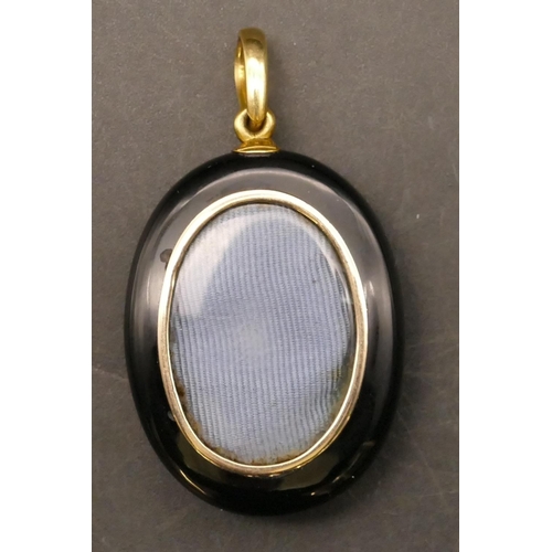 700 - A black onyx oval pendant mounted with pearl cross, 5.2cm high overall