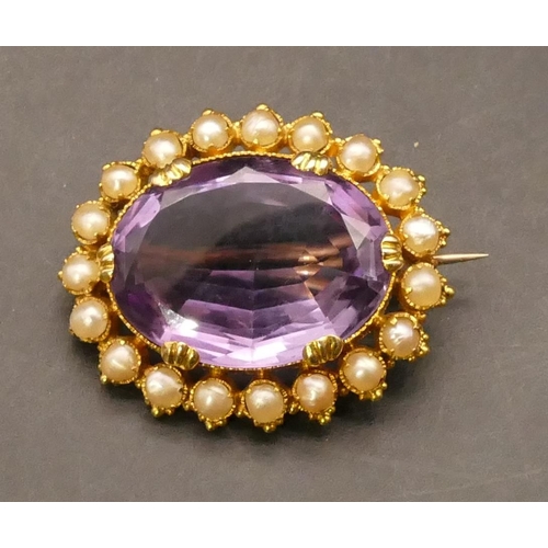 704 - A high carat gold oval brooch set with centre amethyst surrounded by seed pearls (soldering to clasp... 