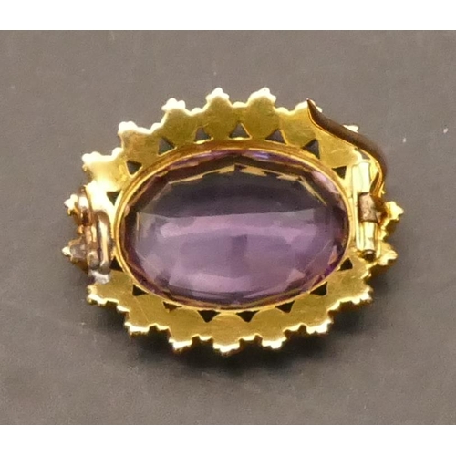 704 - A high carat gold oval brooch set with centre amethyst surrounded by seed pearls (soldering to clasp... 