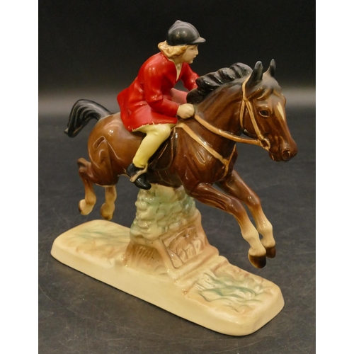 75 - A china figure of a girl on horseback jumping a fence, 18cm high (red coat paint flaking)