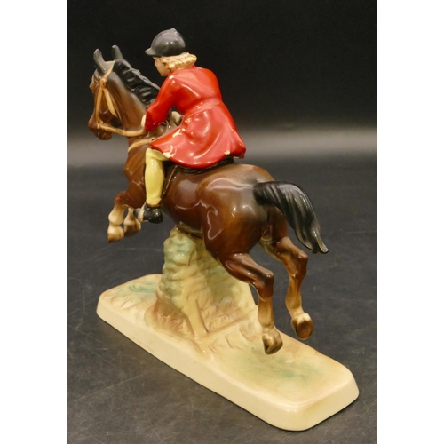 75 - A china figure of a girl on horseback jumping a fence, 18cm high (red coat paint flaking)