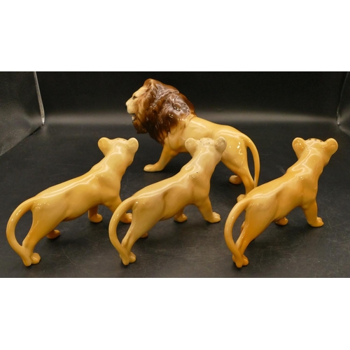 77 - A Beswick figure of a Prowling Lion, 23cm long and 3 Beswick Lion Cubs (4)