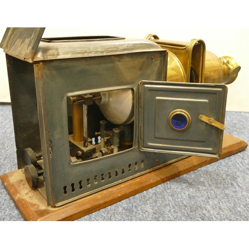 776 - A brass and metal magic lantern on wooden rectangular shaped based, 48cm long overall, 24.5cm high