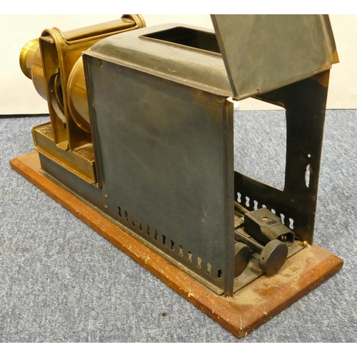 776 - A brass and metal magic lantern on wooden rectangular shaped based, 48cm long overall, 24.5cm high