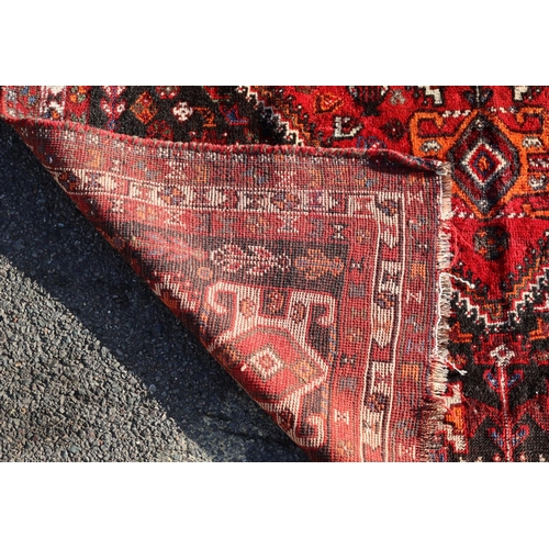 792 - A Persian small carpet on red ground with centre medallion, 255cm x 174cm (worn to 1 end)