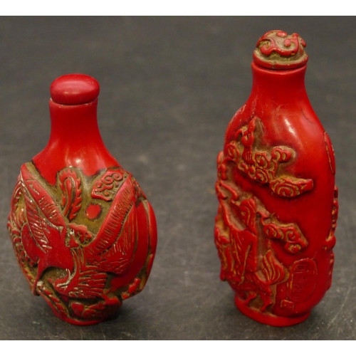 801 - 2 Oriental red snuff bottles with raised figure and animal decoration, largest 8.5cm high