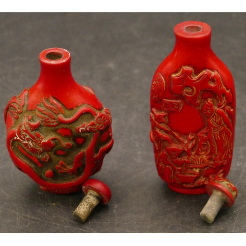 801 - 2 Oriental red snuff bottles with raised figure and animal decoration, largest 8.5cm high