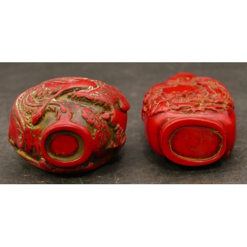 801 - 2 Oriental red snuff bottles with raised figure and animal decoration, largest 8.5cm high