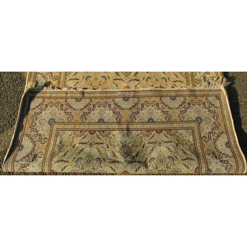 823 - A Persian rug on cream ground with multicoloured allover floral decoration, 218cm by 140cm