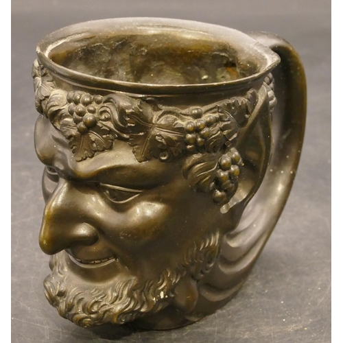 832 - A bronze cup in the form of a figurehead of a Bacchus, 9cm high