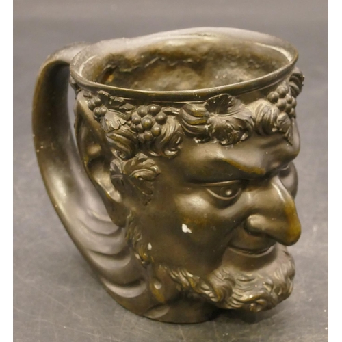 832 - A bronze cup in the form of a figurehead of a Bacchus, 9cm high