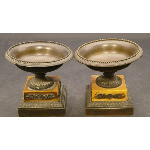 833 - A pair of small bronze urns on part marble square bases, 11cm diameter (stems slightly bent), 10cm h... 