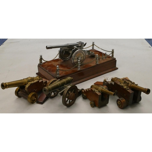 863 - 4 brass miniature table top cannons, largest 19cm long, a similar model of a cannon on a mahogany ba... 