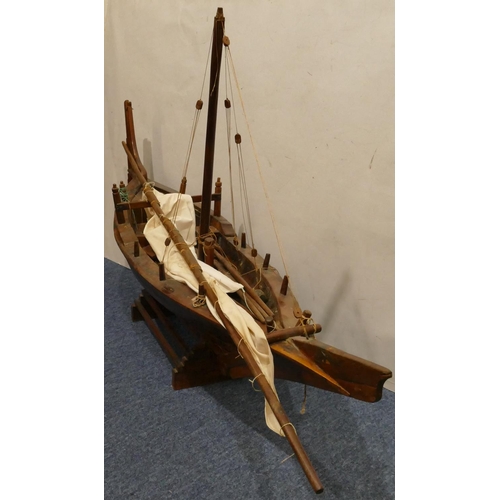 882 - A large model of a sailing boat, with stand, 130cm long