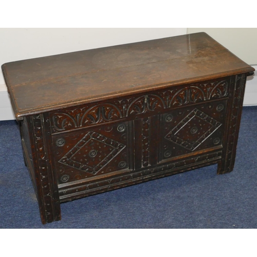 951 - An 18th Century oak dower chest with carved double panelled front, hinged lid on stile feet, 101cm w... 