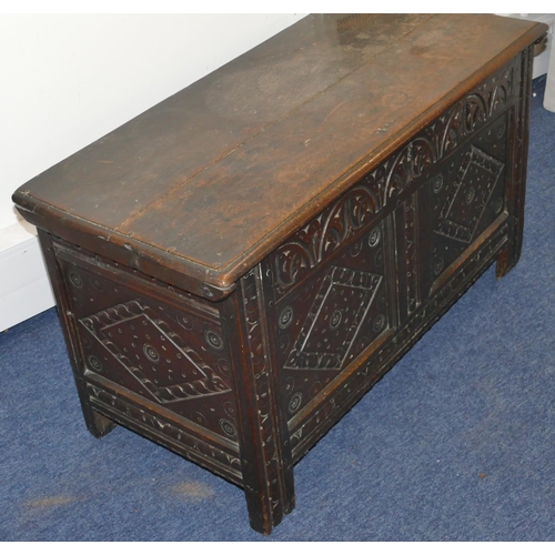 951 - An 18th Century oak dower chest with carved double panelled front, hinged lid on stile feet, 101cm w... 