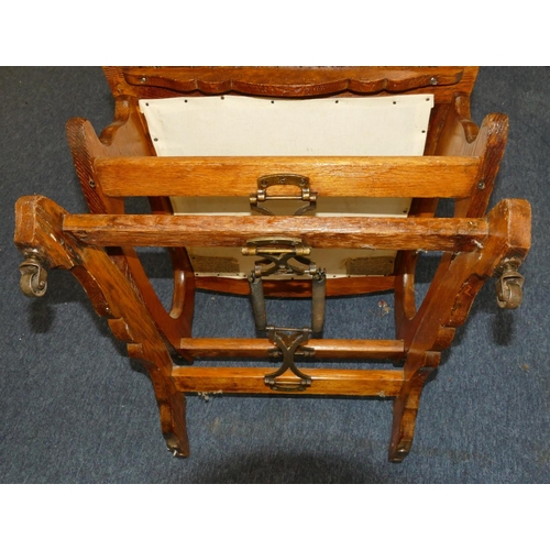 960 - An oak American rocking chair with red overstuffed and studded seat and back with padded arms, on ca... 