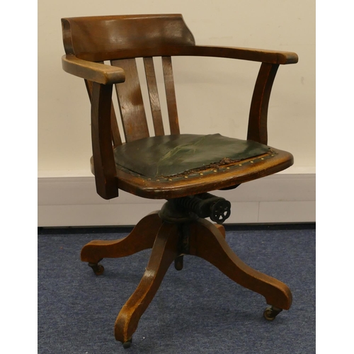 962 - A 1930's oak swivel tub desk chair with slat back, leather studded overstuffed seat (in need of rest... 