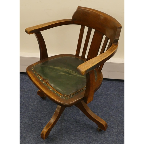 962 - A 1930's oak swivel tub desk chair with slat back, leather studded overstuffed seat (in need of rest... 