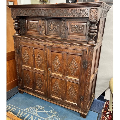 984 - An 18th century oak court cupboard, centre panel flanked by 2 carved panelled doors above 2 large ca... 