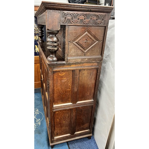 984 - An 18th century oak court cupboard, centre panel flanked by 2 carved panelled doors above 2 large ca... 