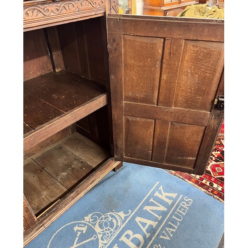 984 - An 18th century oak court cupboard, centre panel flanked by 2 carved panelled doors above 2 large ca... 