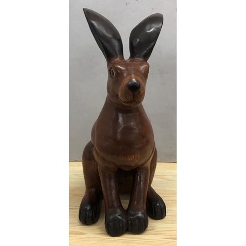 8065 - A large carved wood rabbit, 48.5cm high overall.