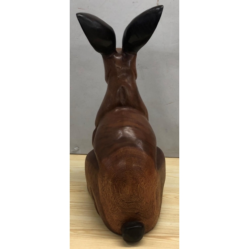 8065 - A large carved wood rabbit, 48.5cm high overall.