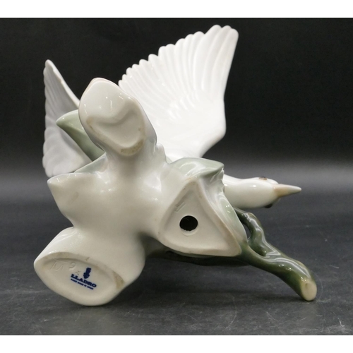 191 - A Lladro figure of a perched white bird with wings aloft, 27.5cm high