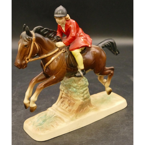 75 - A china figure of a girl on horseback jumping a fence, 18cm high (red coat paint flaking)