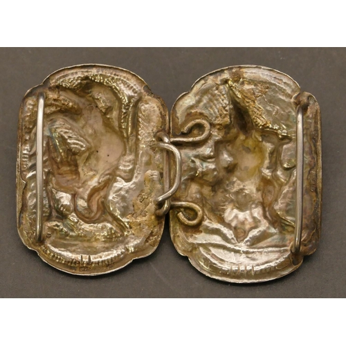 510 - An Eastern silver 2-piece buckle with raised figure motifs, 7.7cm wide overall, 38.5 grams