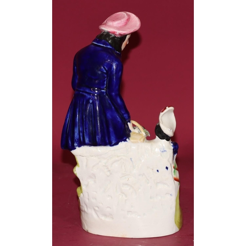 100 - A 19th Century Staffordshire hollow base figure of a gardener and child, 24cm high