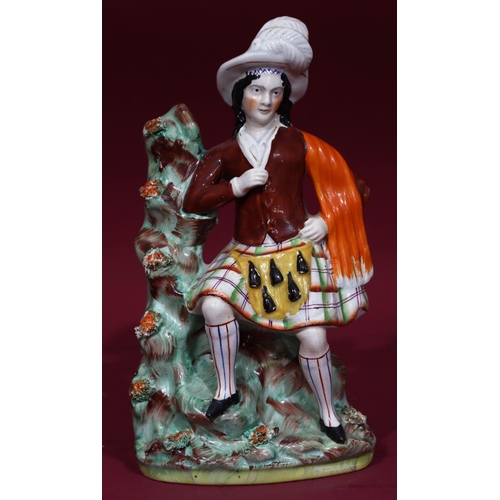 115 - A 19th Century Staffordshire figure of Scotsman seated by a tree, 31cm high