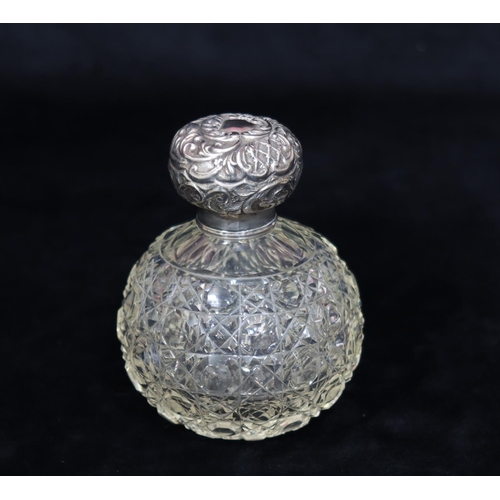 184 - A cut glass round bulbous dressing table bottle with London silver top, embossed with floral and scr... 