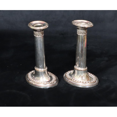 215 - A pair of Sheffield plated oval candlesticks with chamfer decoration, on sweeping bases with leaf de... 