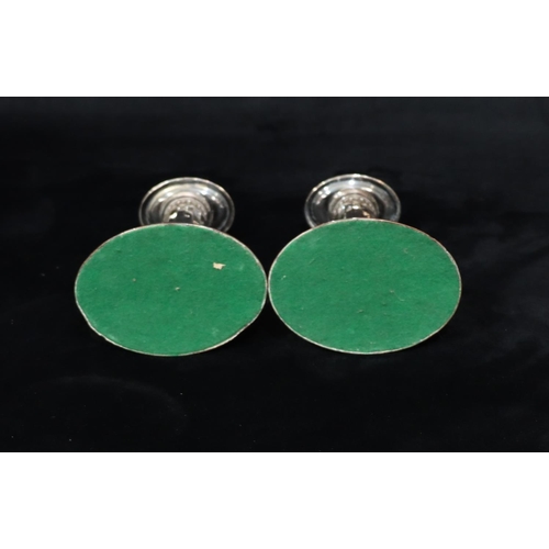 215 - A pair of Sheffield plated oval candlesticks with chamfer decoration, on sweeping bases with leaf de... 