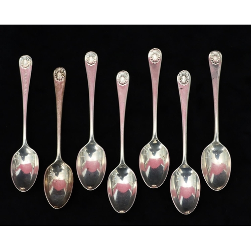 225 - A Harlequin set of 7 Sheffield silver teaspoons with scroll tails and shell mounts, maker's mark TB&... 