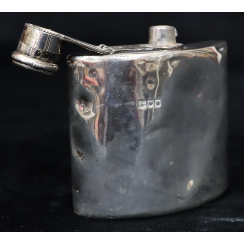 235 - A London small silver concaved shaped hip flask with screw hinged lid (dented but not split), 8cm hi... 