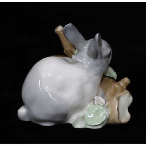 24 - A Lladro figure of a rabbit standing on a log, 8.5cm high