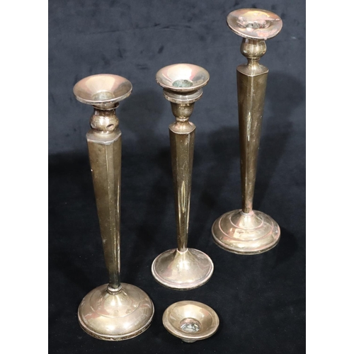 254 - 3 various similar Sterling silver candlesticks on tapering stems with round sweeping weighted bases ... 