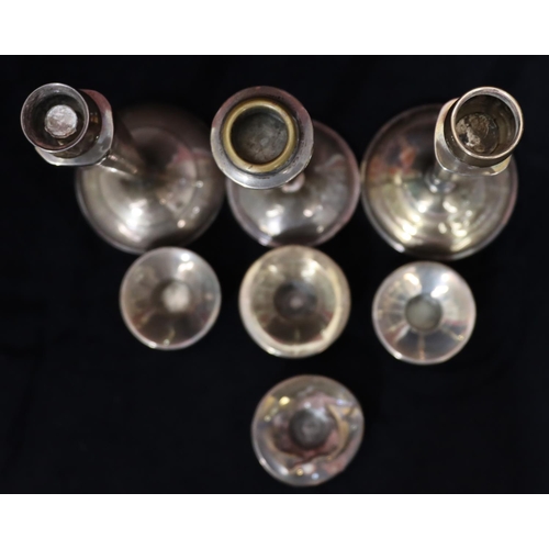 254 - 3 various similar Sterling silver candlesticks on tapering stems with round sweeping weighted bases ... 