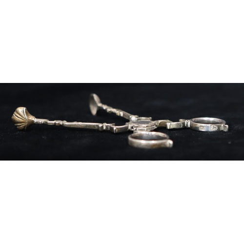 280 - A pair of Georgian silver sugar nips with chased floral and leaf decoration, scroll shaped arm, make... 