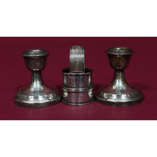 315 - 3 odd silver napkin rings, 2oz, a pair of Chester silver dwarf candlesticks (dented) (5)