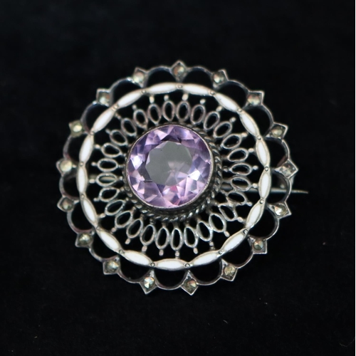 342 - A silver circular and white enamelled brooch set with amethyst