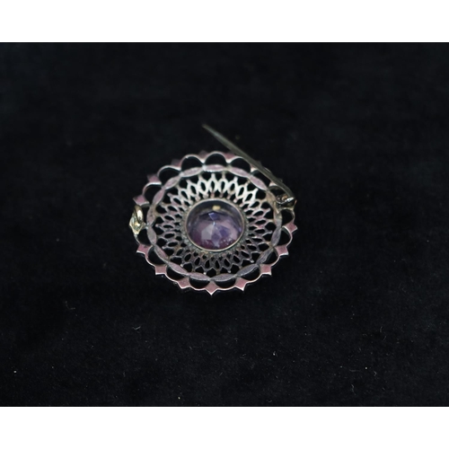 342 - A silver circular and white enamelled brooch set with amethyst