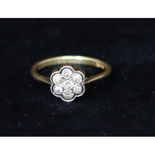 379 - An 18ct gold floral cluster ring set with 7 diamonds, Size M/N, 2.2 grams